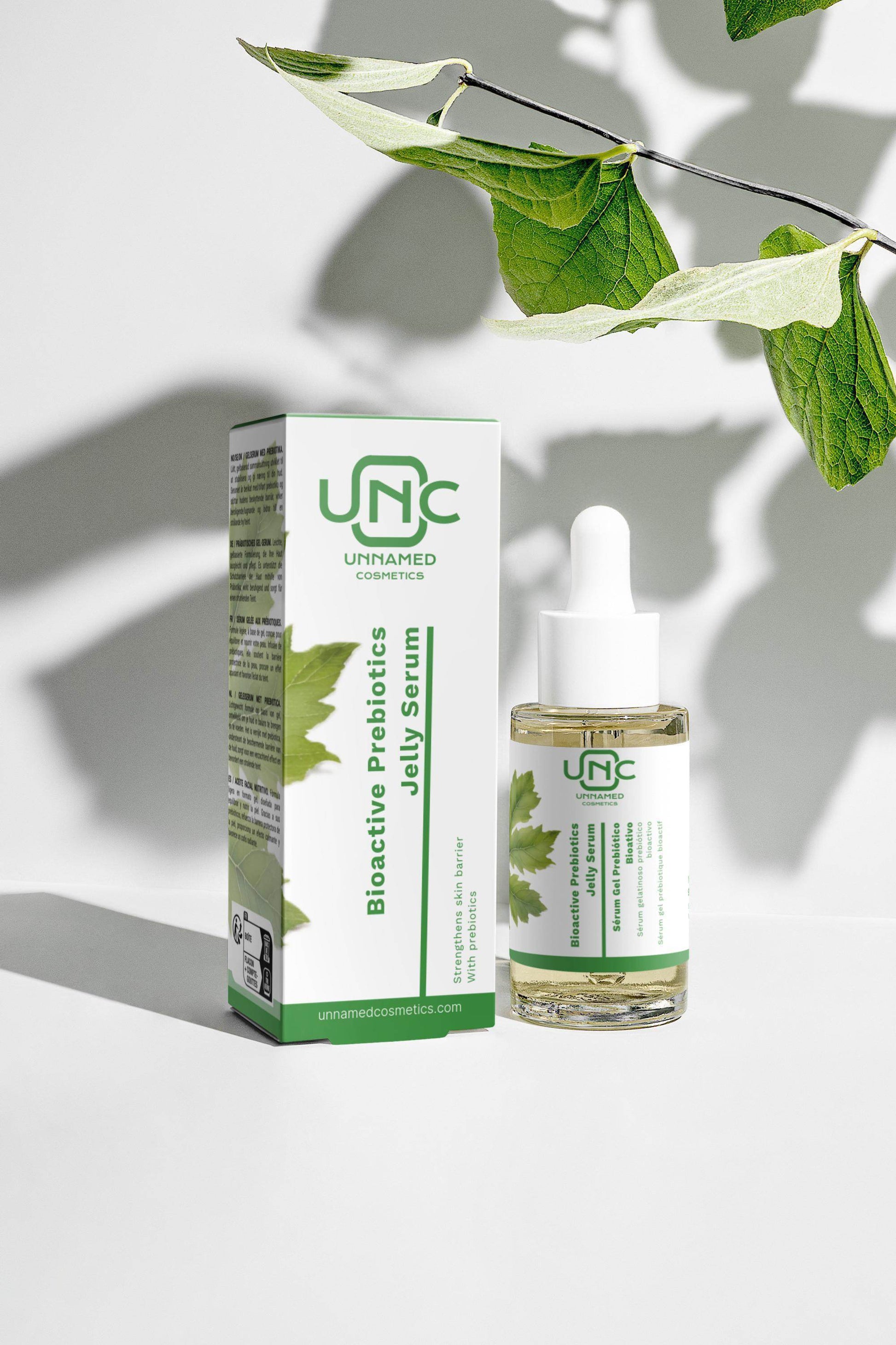 Sérum prebiótico vegan da Unnamed Cosmetics em embalagem com folhas verdes ao fundo